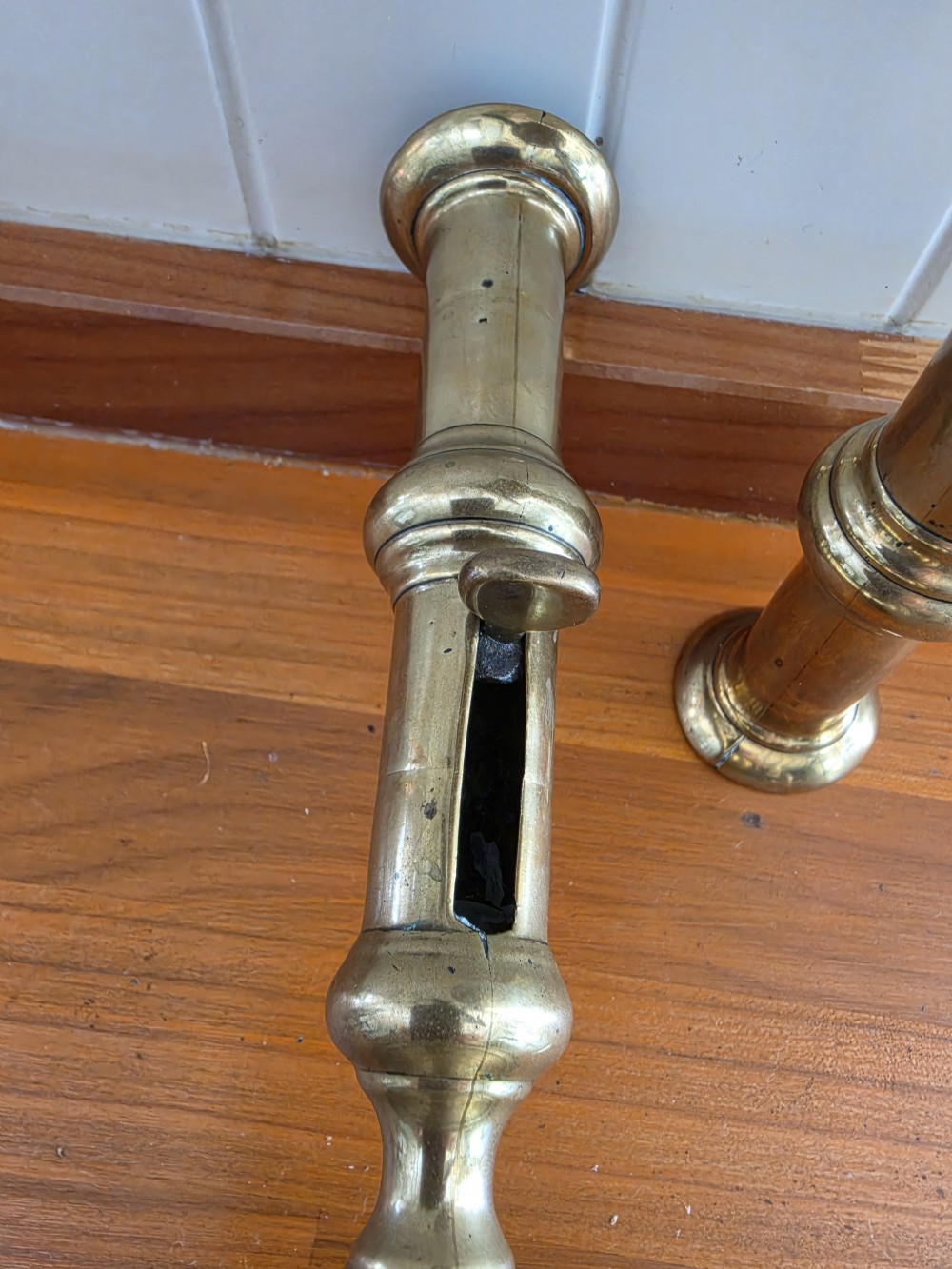 A pair of mid-18th-century seamed brass candlesticks featuring turned stems, slide ejector mechanisms, and circular stepped bases. View IV
