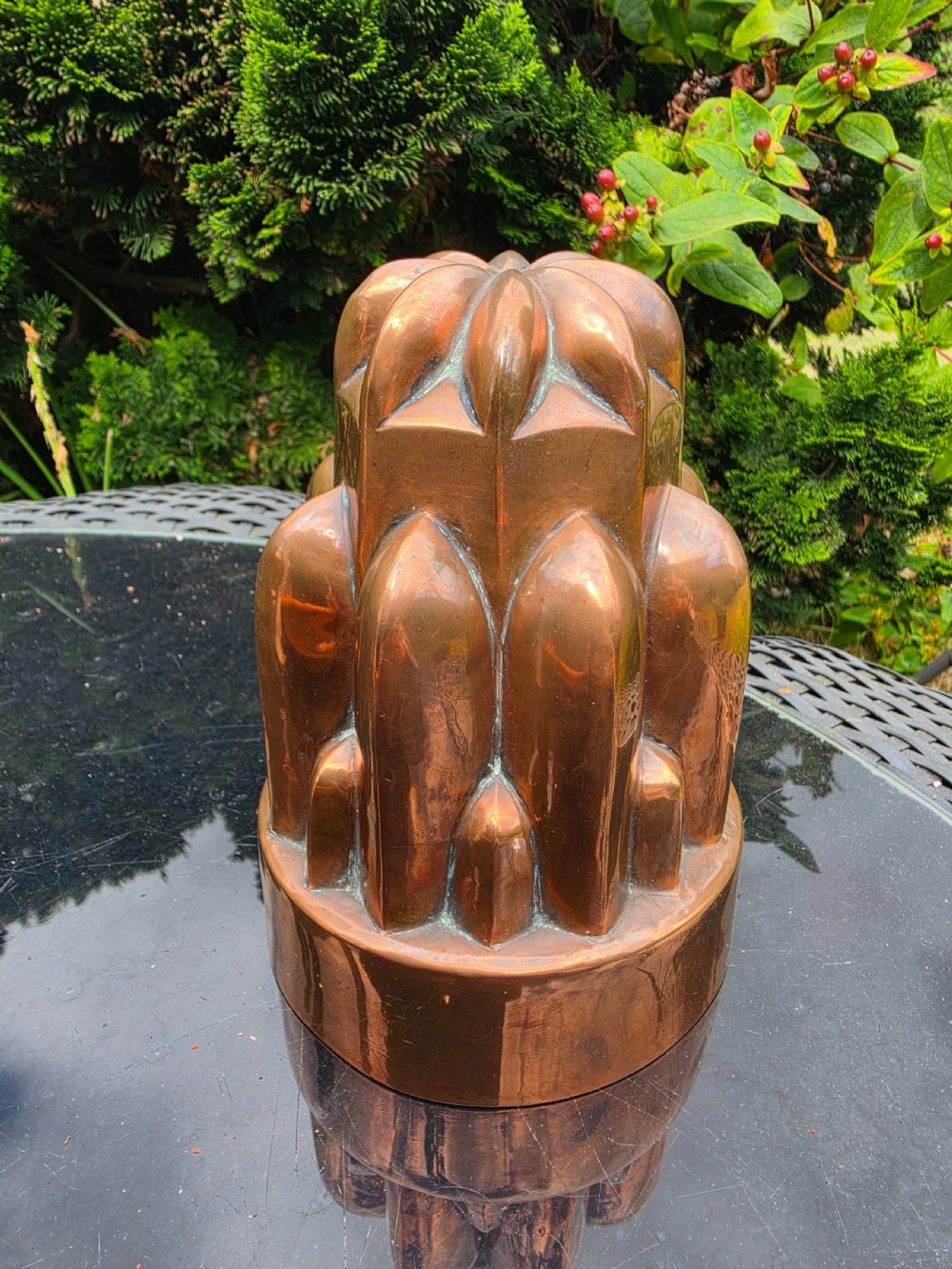 A tiered Victorian copper jelly mould featuring geometric fluted and arched column details.