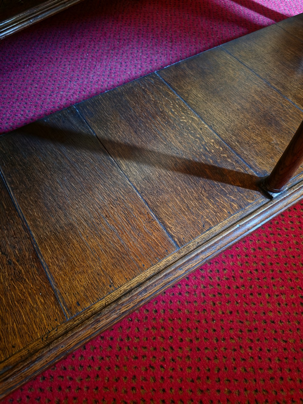 A 19th-century dark oak potboard dresser base featuring three inline drawers with brass swan-neck handles, geometric inlay details, carved arches, and an open lower shelf. View V