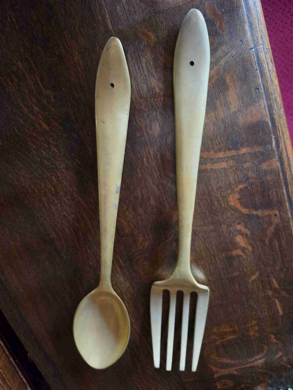 A pair of vintage brass wall plaques shaped as a large spoon and fork with pre-drilled mounting holes at the top of the handles.