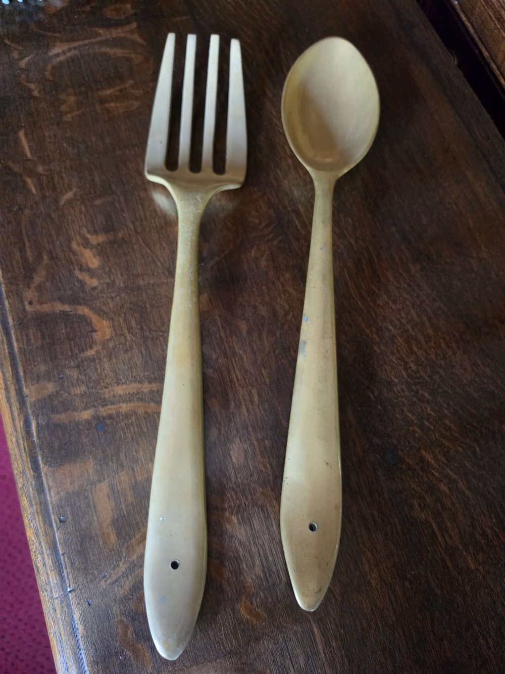 A pair of vintage brass wall plaques shaped as a large spoon and fork with pre-drilled mounting holes at the top of the handles. View IV
