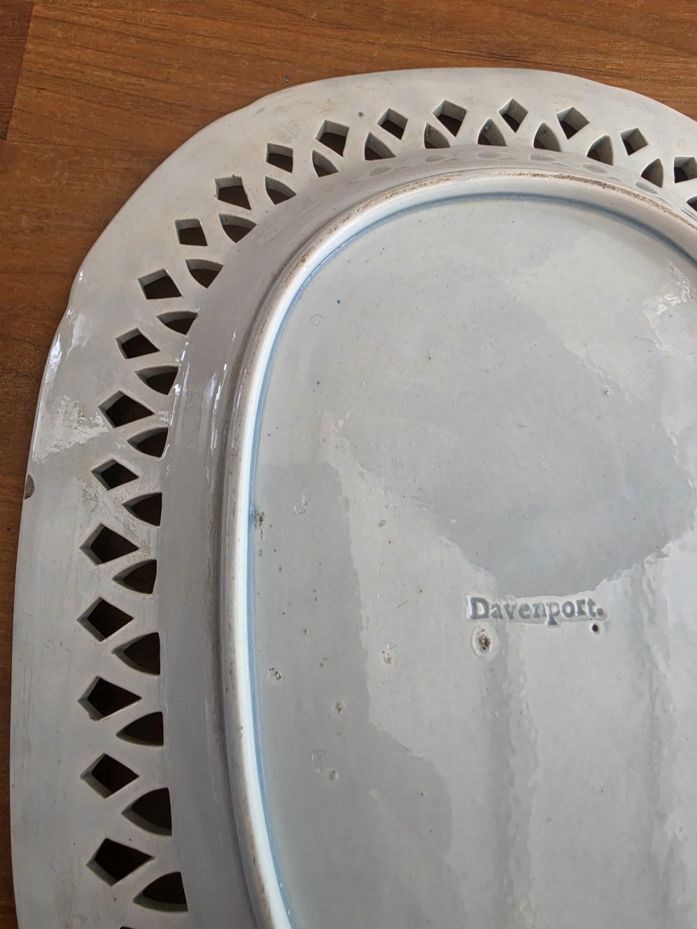 An early 19th-century oval blue and white earthenware platter with a pierced reticulated rim and central pastoral landscape scene. View II