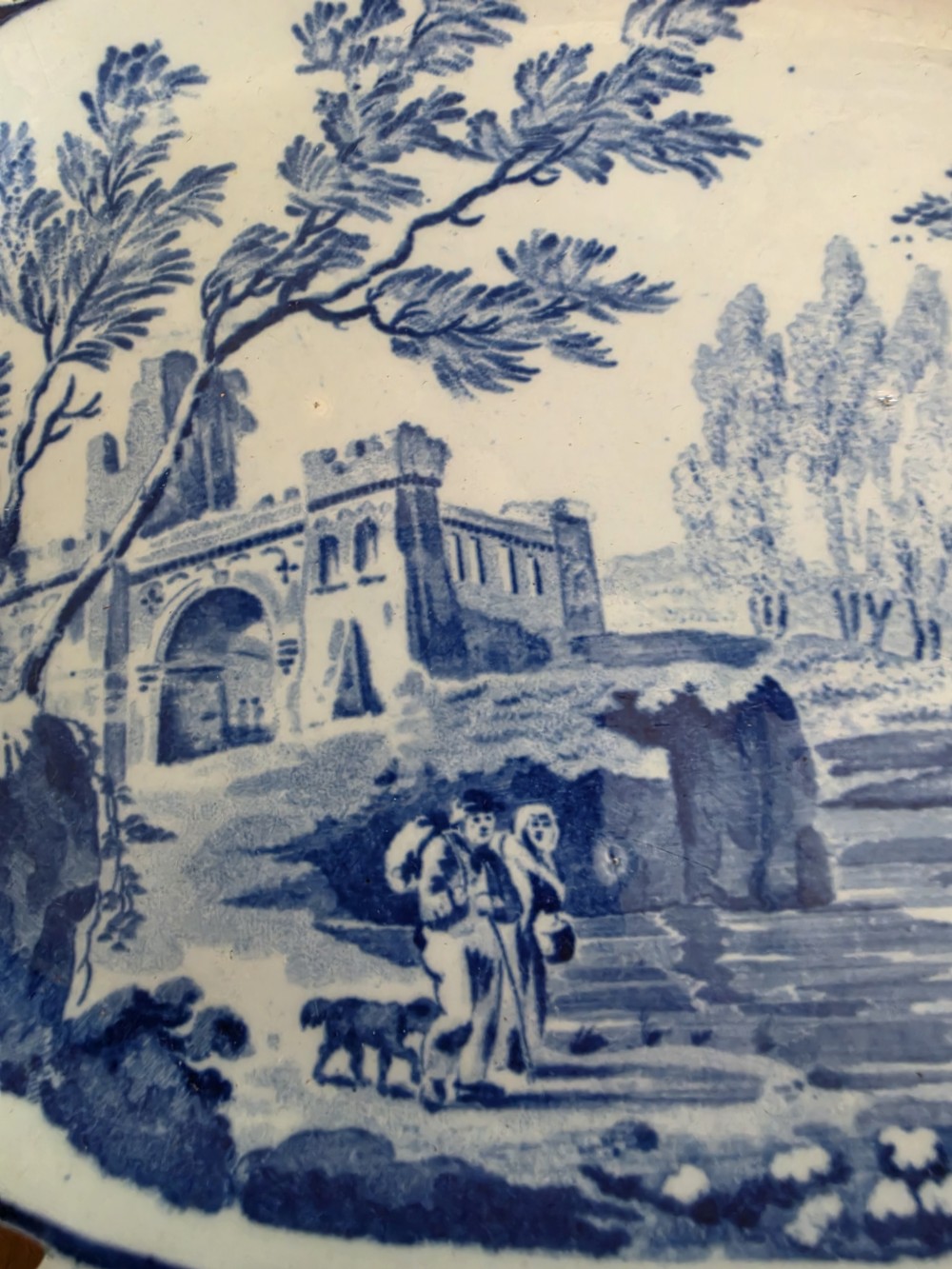 An early 19th-century oval blue and white earthenware platter with a pierced reticulated rim and central pastoral landscape scene. View III