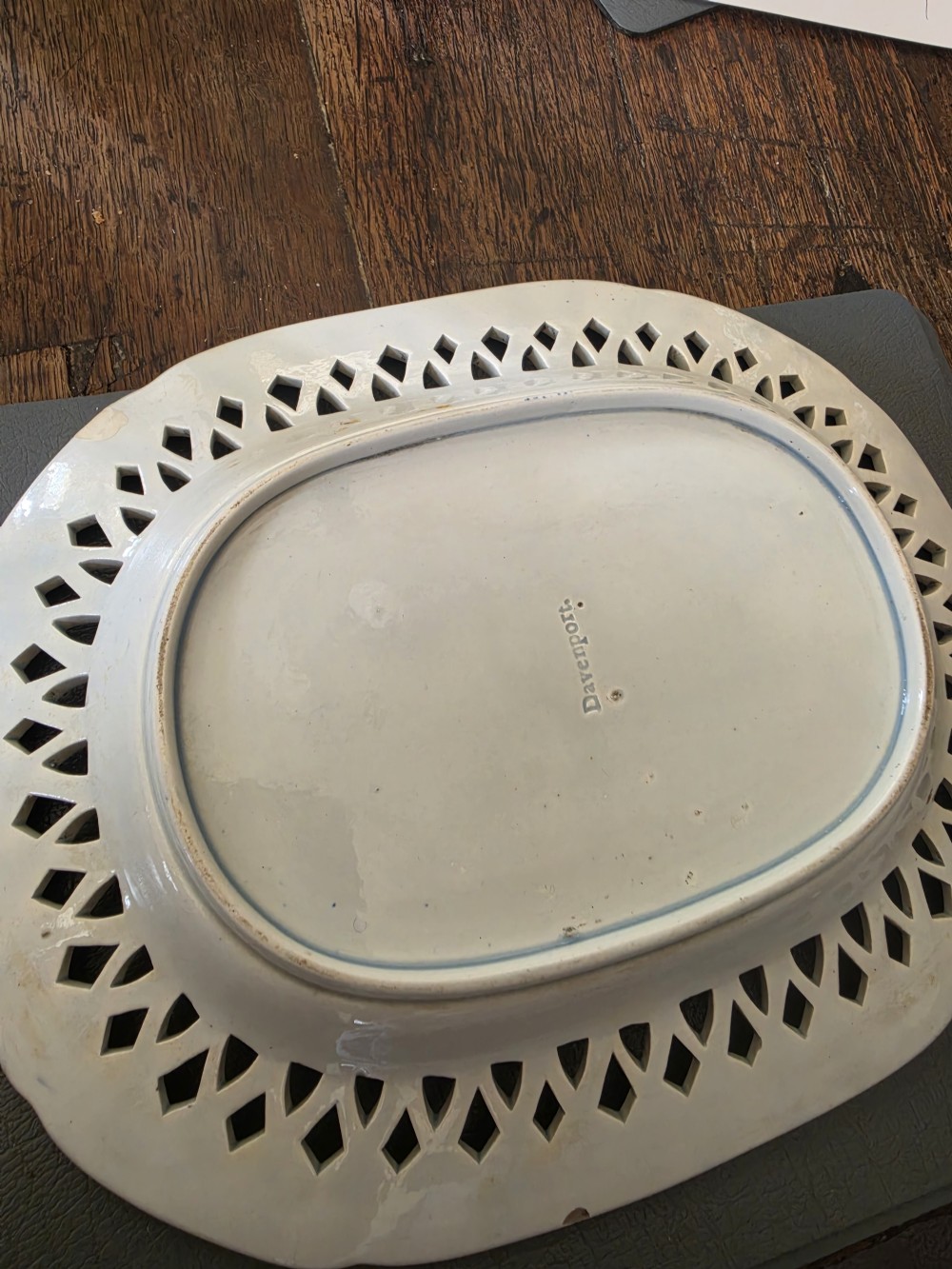 An early 19th-century oval blue and white earthenware platter with a pierced reticulated rim and central pastoral landscape scene. View VI