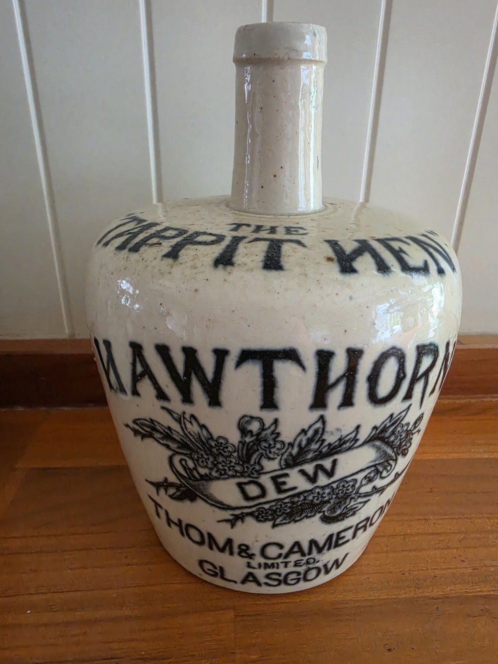A set of four 19th-century cream stoneware advertising whisky flasks featuring black transfer-printed text and brown glazed spouts. View VII