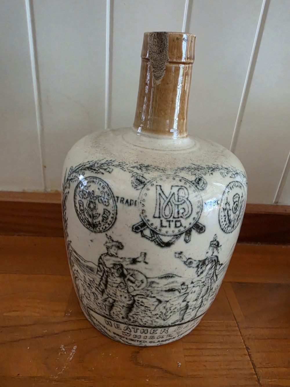 A set of four 19th-century cream stoneware advertising whisky flasks featuring black transfer-printed text and brown glazed spouts. View VIII