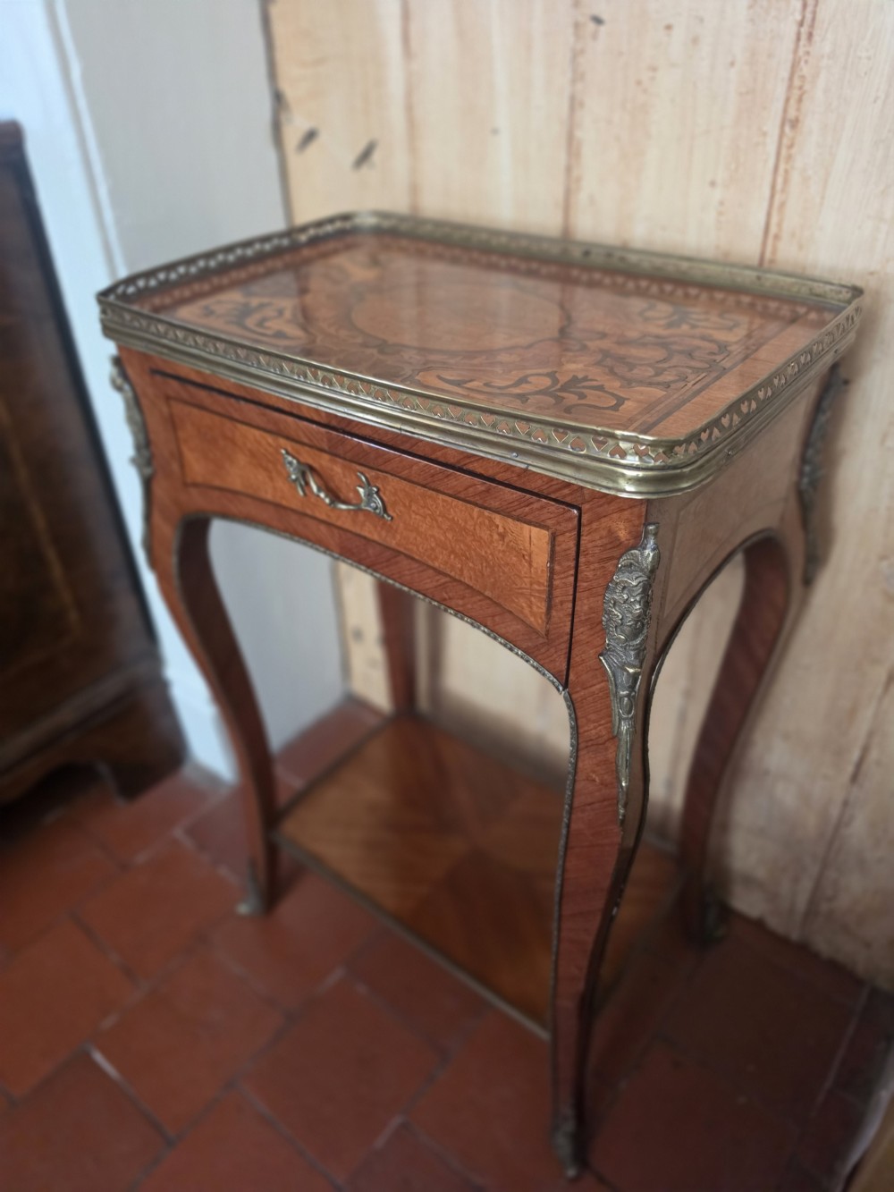 A 19th-century French style marquetry inlaid side table featuring a pierced brass gallery rim, single drawer, lower tier shelf, and cabriole legs with brass mounts. View II