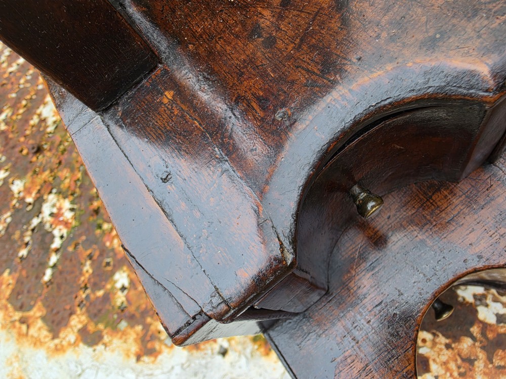 An eighteenth-century George I patinated dark walnut toilet mirror featuring an arched adjustable swing glass over a two-tier serpentine drawer base with brass hardware. View V