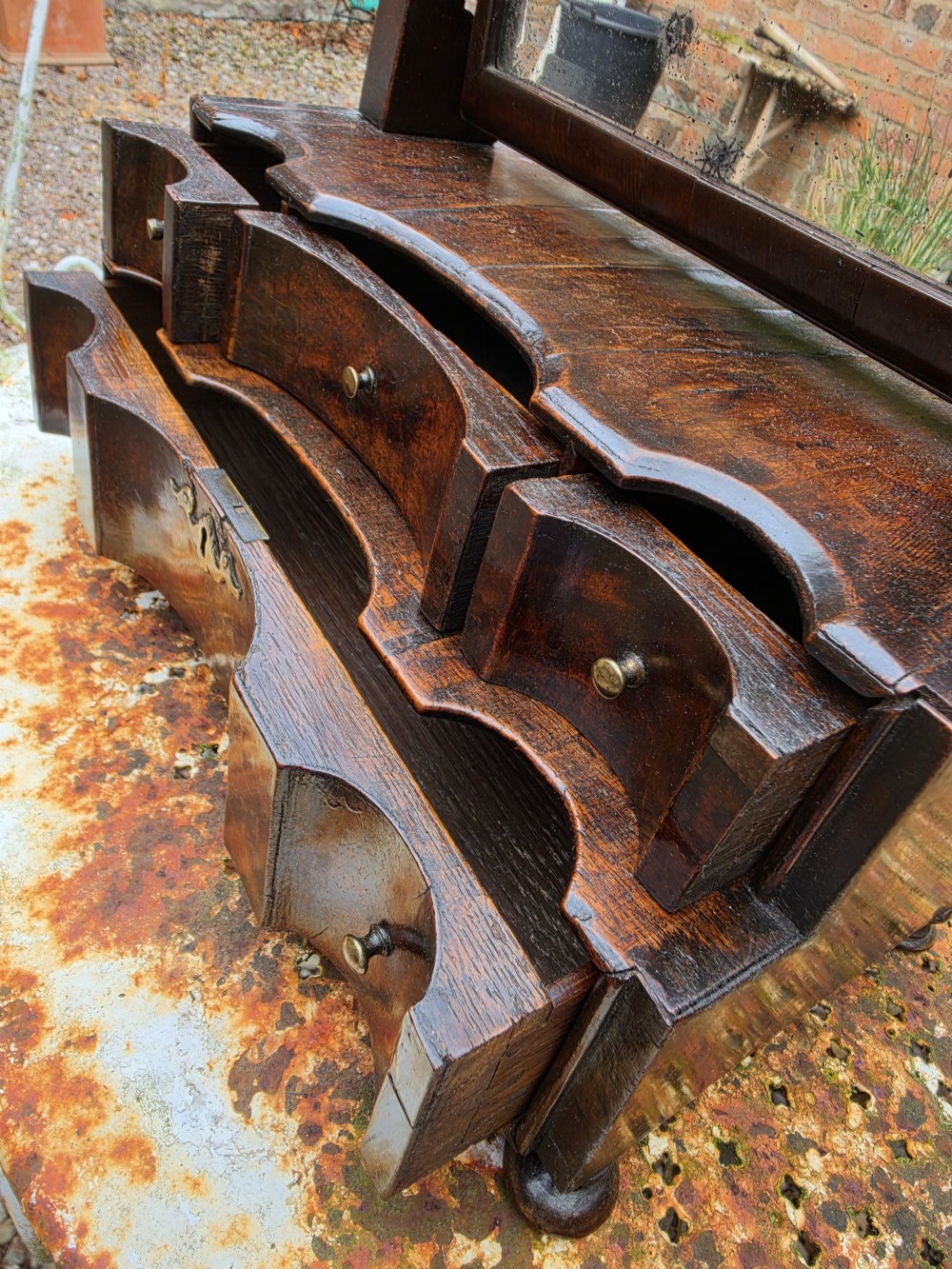 An eighteenth-century George I patinated dark walnut toilet mirror featuring an arched adjustable swing glass over a two-tier serpentine drawer base with brass hardware. View VI