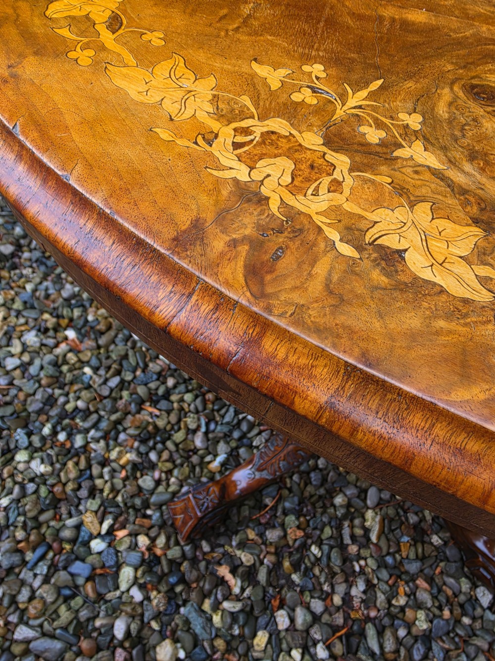 An oval 19th-century burr walnut centre table featuring floral marquetry inlay, supported by turned central columns and four carved legs. View III