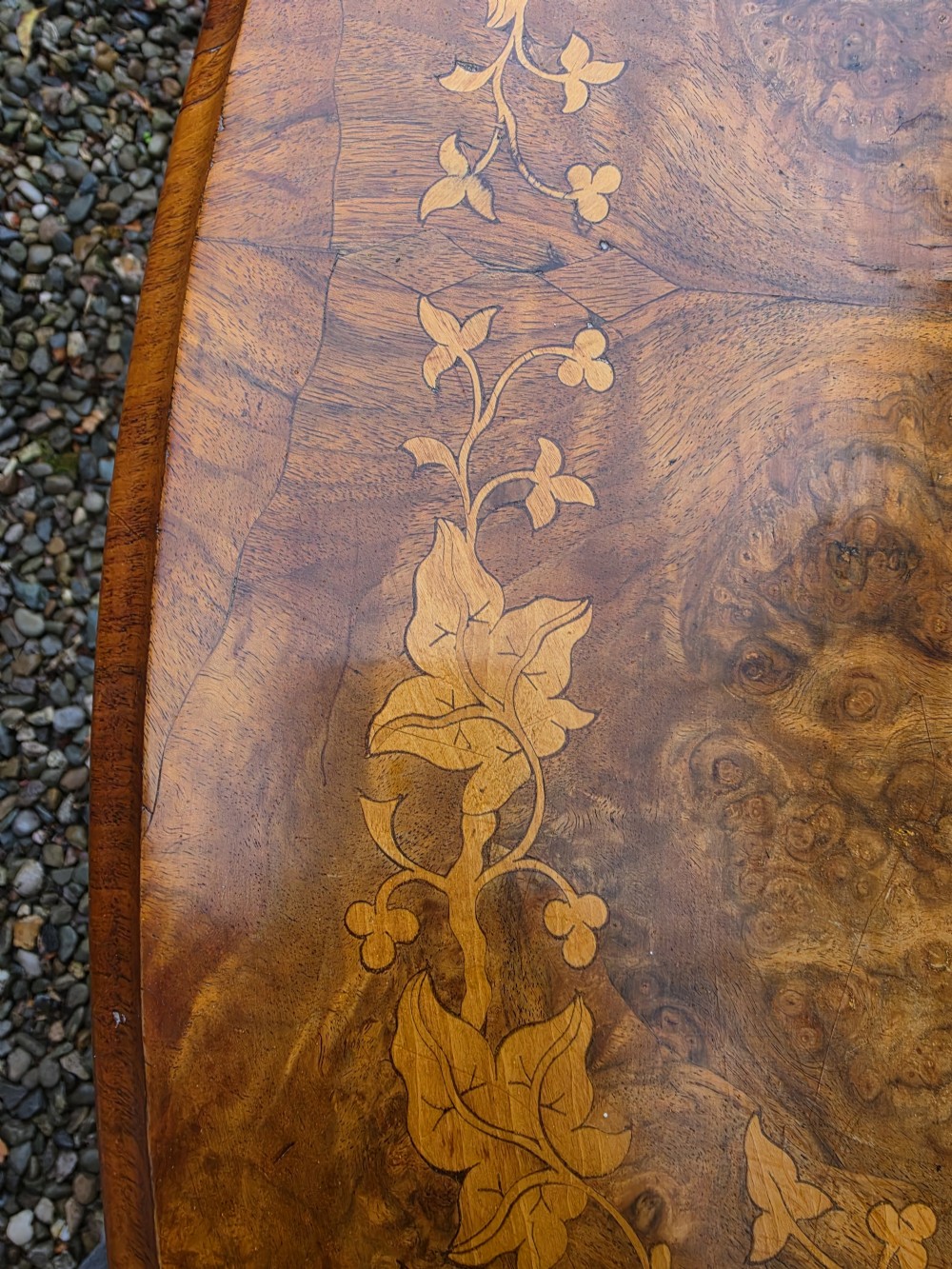 An oval 19th-century burr walnut centre table featuring floral marquetry inlay, supported by turned central columns and four carved legs. View VI
