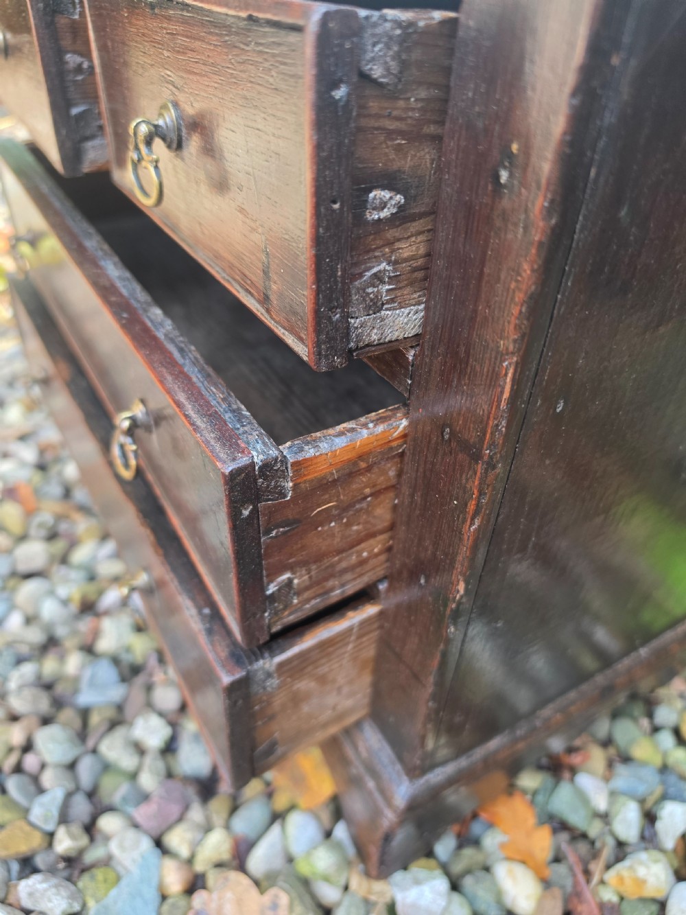 An 18th-century dark oak chest featuring two short drawers over two long drawers with brass drop handles, resting on bracket feet. View III