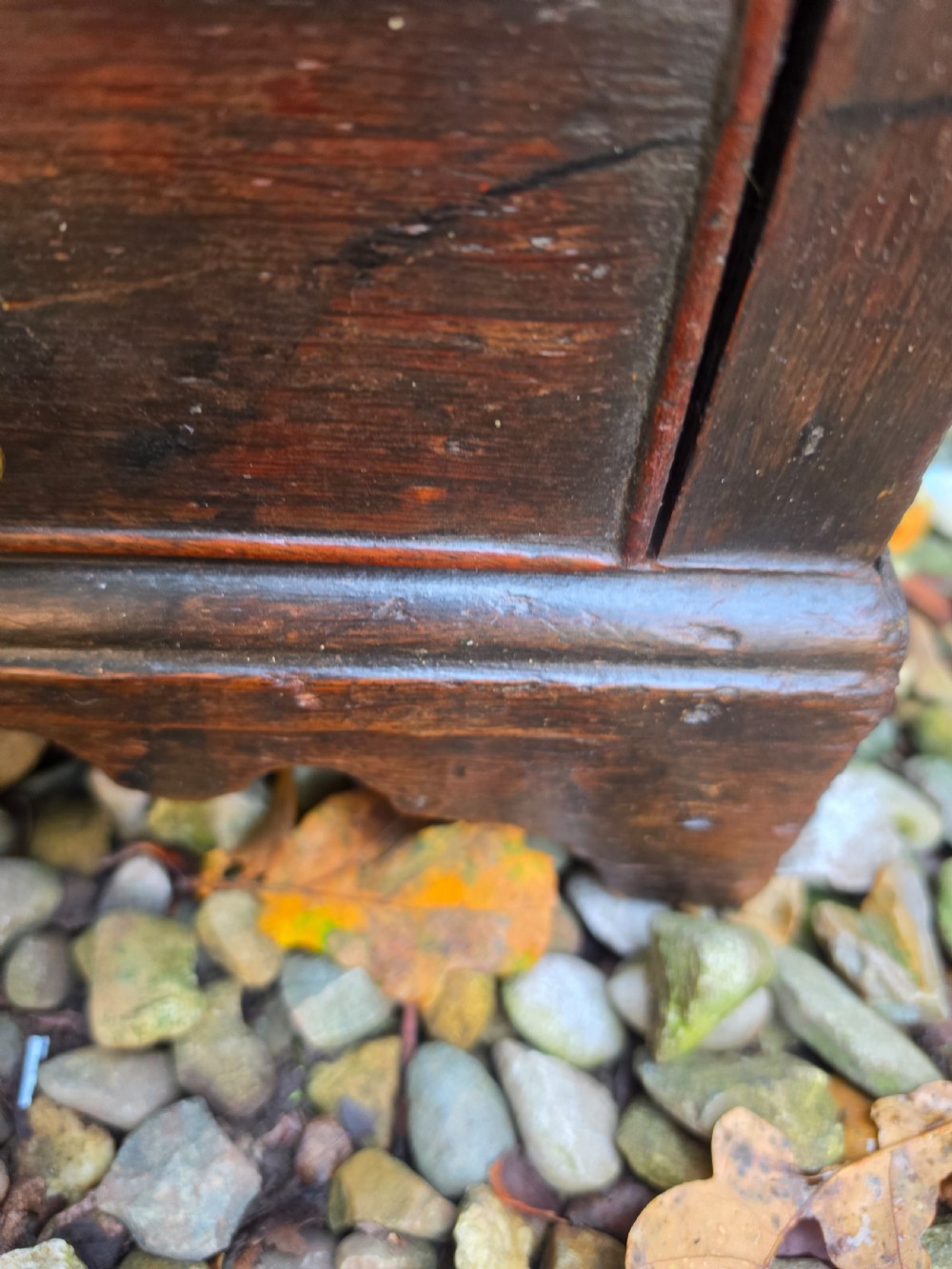 An 18th-century dark oak chest featuring two short drawers over two long drawers with brass drop handles, resting on bracket feet. View IV
