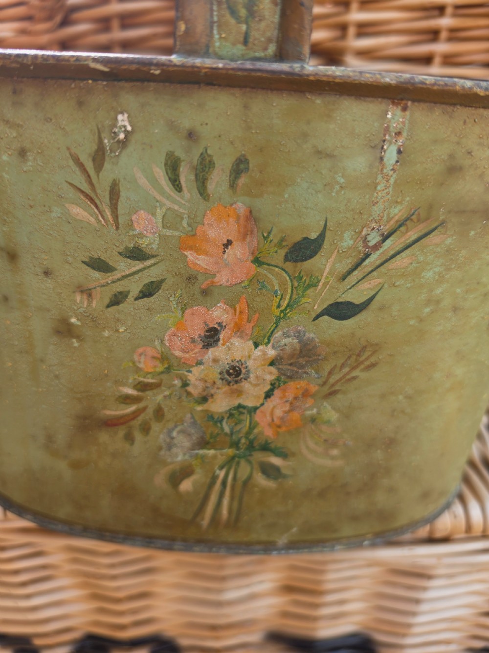 An antique sage green painted metal two-bottle wine carrier with a central divider, high handle, and hand-painted floral bouquet. View III