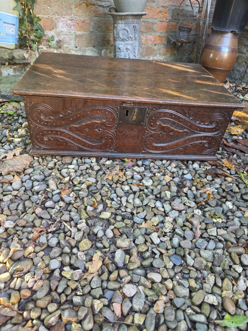A rectangular dark oak bible box featuring carved scroll detailing on the front panel and a central iron keyplate. View III