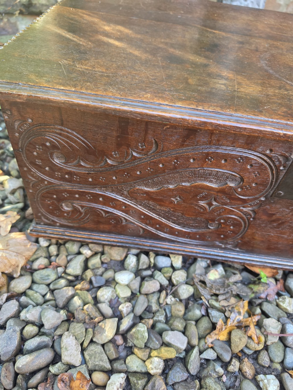 A rectangular dark oak bible box featuring carved scroll detailing on the front panel and a central iron keyplate. View IV