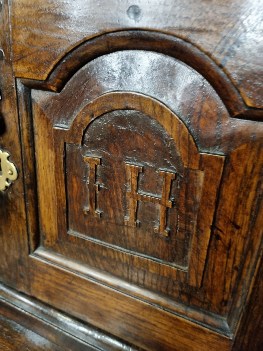 An eighteenth-century dark oak Welsh tridarn featuring a three-tiered structure with carved arched panels, turned pillars, and an inscribed date. View IX