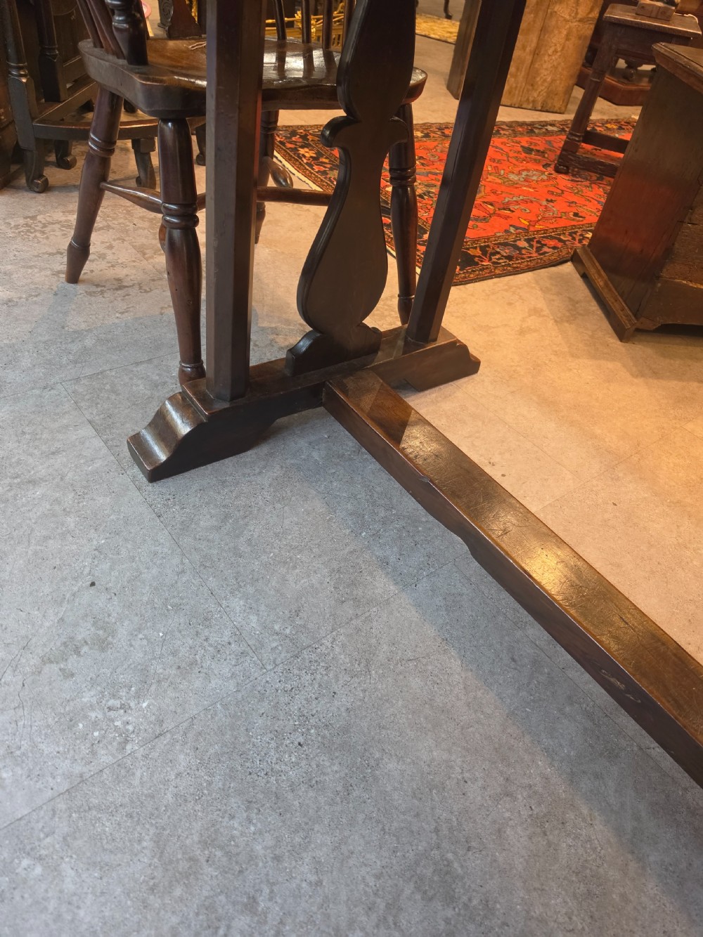 A large 19th-century dark elm refectory dining table featuring a solid planked top supported by a trestle stretcher base. View II