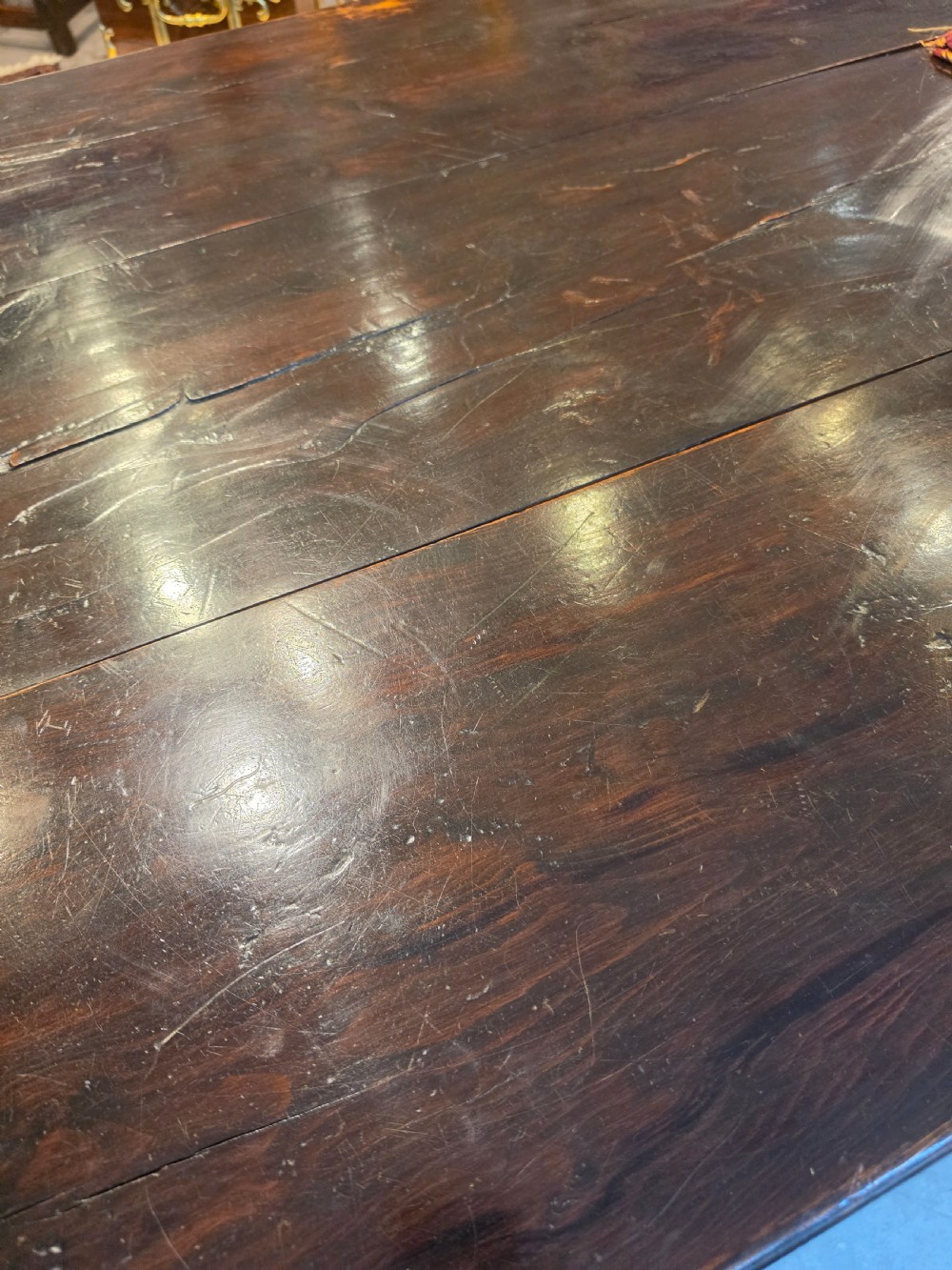 A large 19th-century dark elm refectory dining table featuring a solid planked top supported by a trestle stretcher base. View III