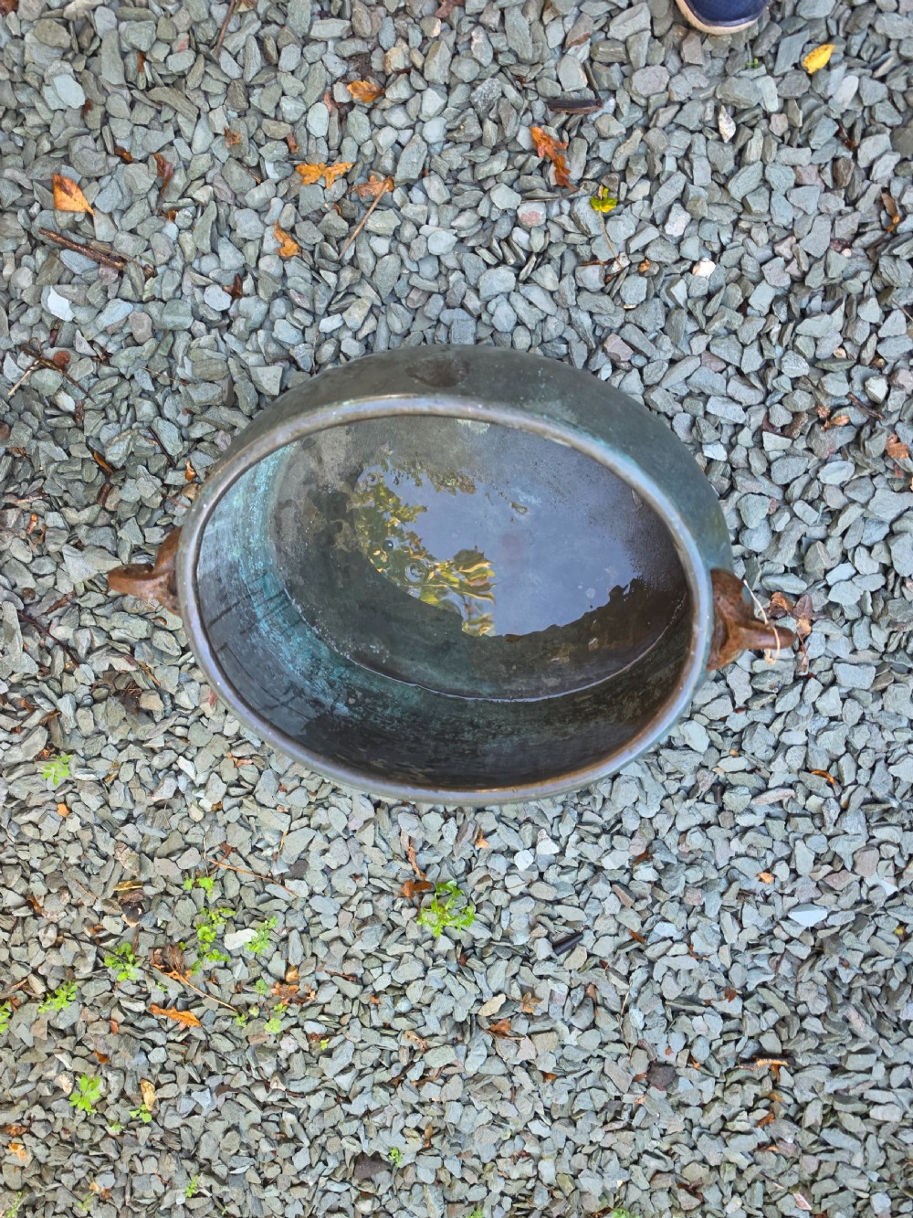 A large 19th-century copper cauldron with a rounded body, rolled rim, iron handles, and a verdigris patina. View II
