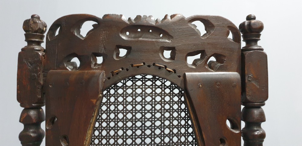 A high-backed dark oak carver chair featuring an oval cane backrest, barley twist posts, hand-carved cresting, and a patterned seat cushion. View XII
