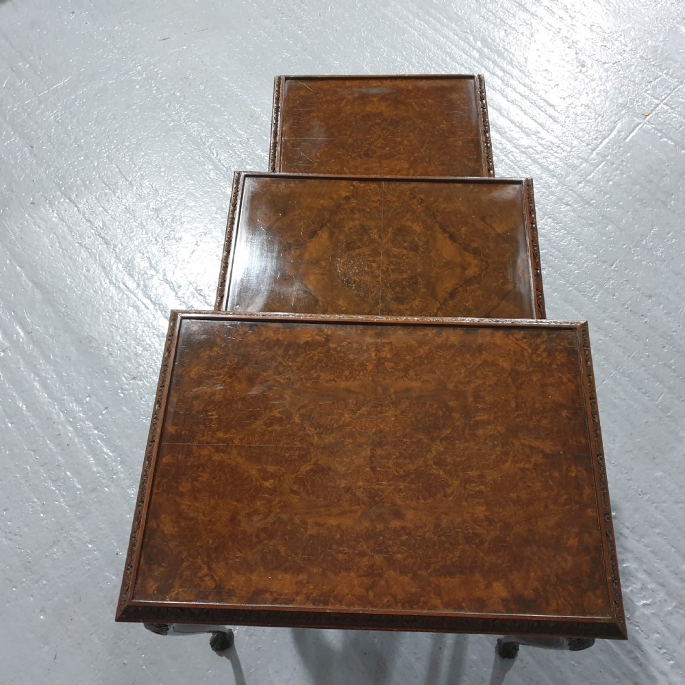 A set of three graduated burr walnut nesting tables with carved borders, cabriole legs, and claw and ball feet. View IV