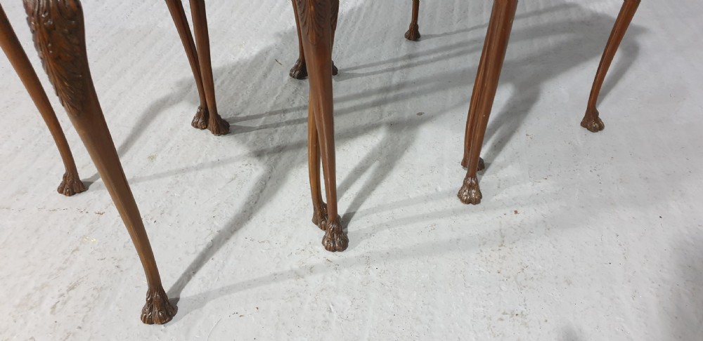 A set of three graduated burr walnut nesting tables with carved borders, cabriole legs, and claw and ball feet. View VIII