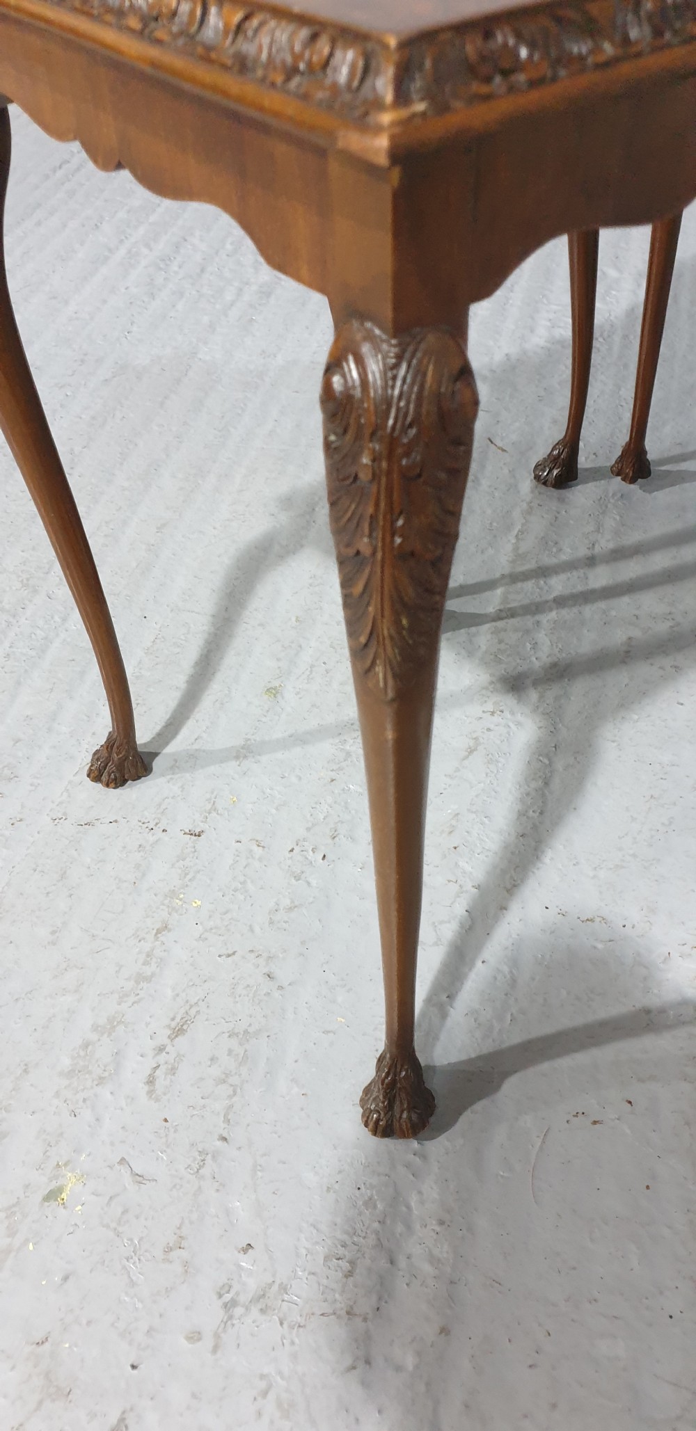 A set of three graduated burr walnut nesting tables with carved borders, cabriole legs, and claw and ball feet. View IX