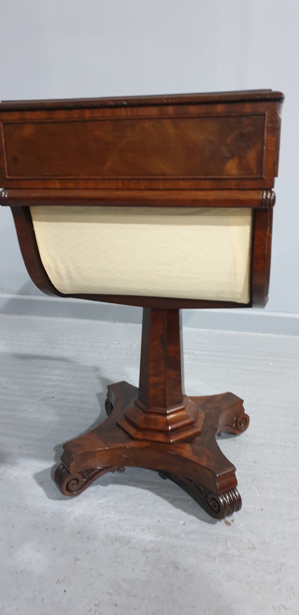 A William IV mahogany work box table featuring a single drawer over a cream fabric-lined storage well, supported on a central pedestal and quadform base with scroll feet. View V