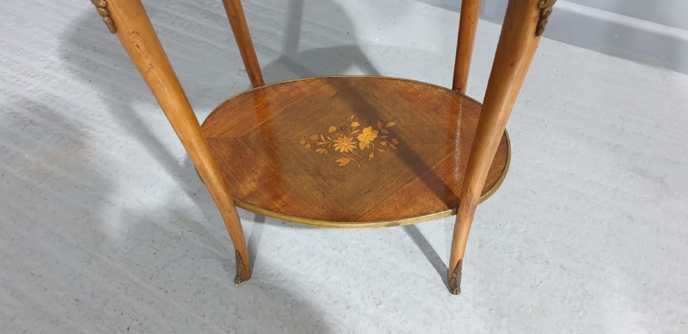 An oval French-style two-tier occasional table featuring floral marquetry inlay, slender cabriole legs, and gilt-bronze mounts. View II