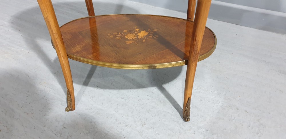 An oval French-style two-tier occasional table featuring floral marquetry inlay, slender cabriole legs, and gilt-bronze mounts. View III