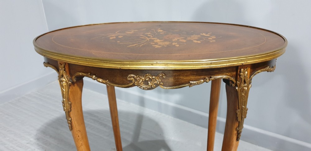 An oval French-style two-tier occasional table featuring floral marquetry inlay, slender cabriole legs, and gilt-bronze mounts. View IV