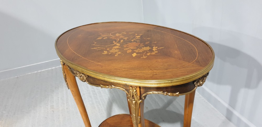 An oval French-style two-tier occasional table featuring floral marquetry inlay, slender cabriole legs, and gilt-bronze mounts. View VII