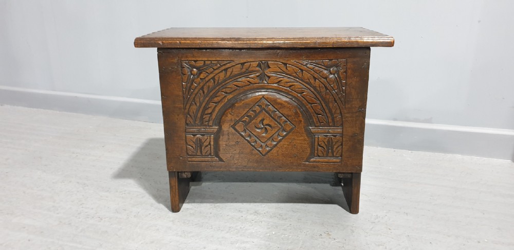 A small dark oak coffer featuring detailed arcaded and lozenge carved motifs on the front panel. View III