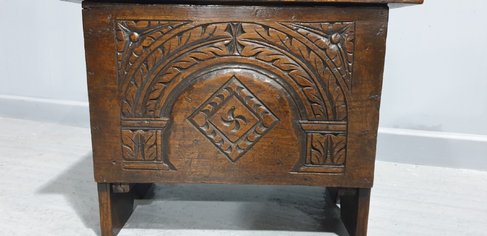 A small dark oak coffer featuring detailed arcaded and lozenge carved motifs on the front panel. View IV