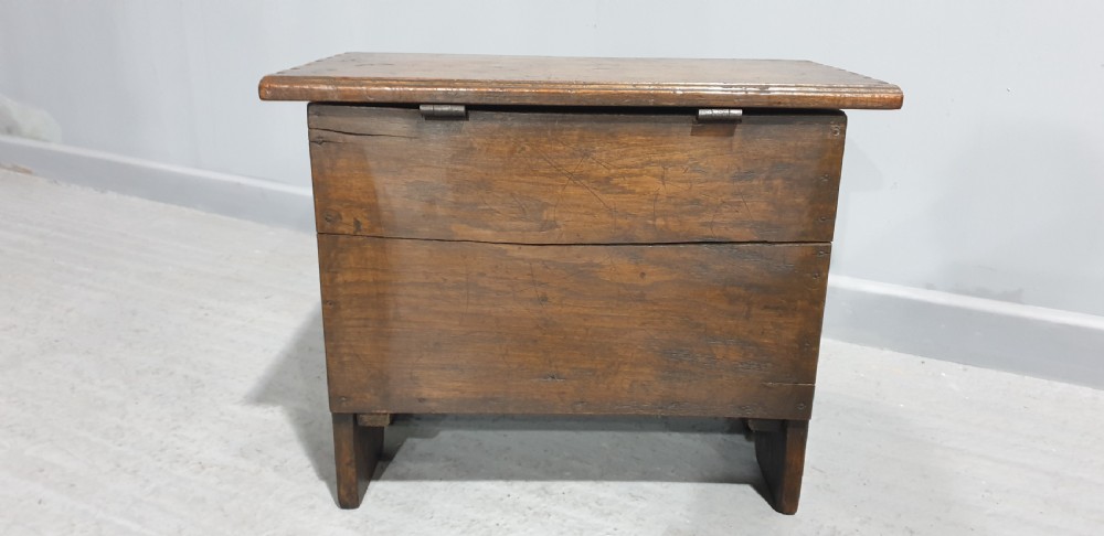 A small dark oak coffer featuring detailed arcaded and lozenge carved motifs on the front panel. View VI
