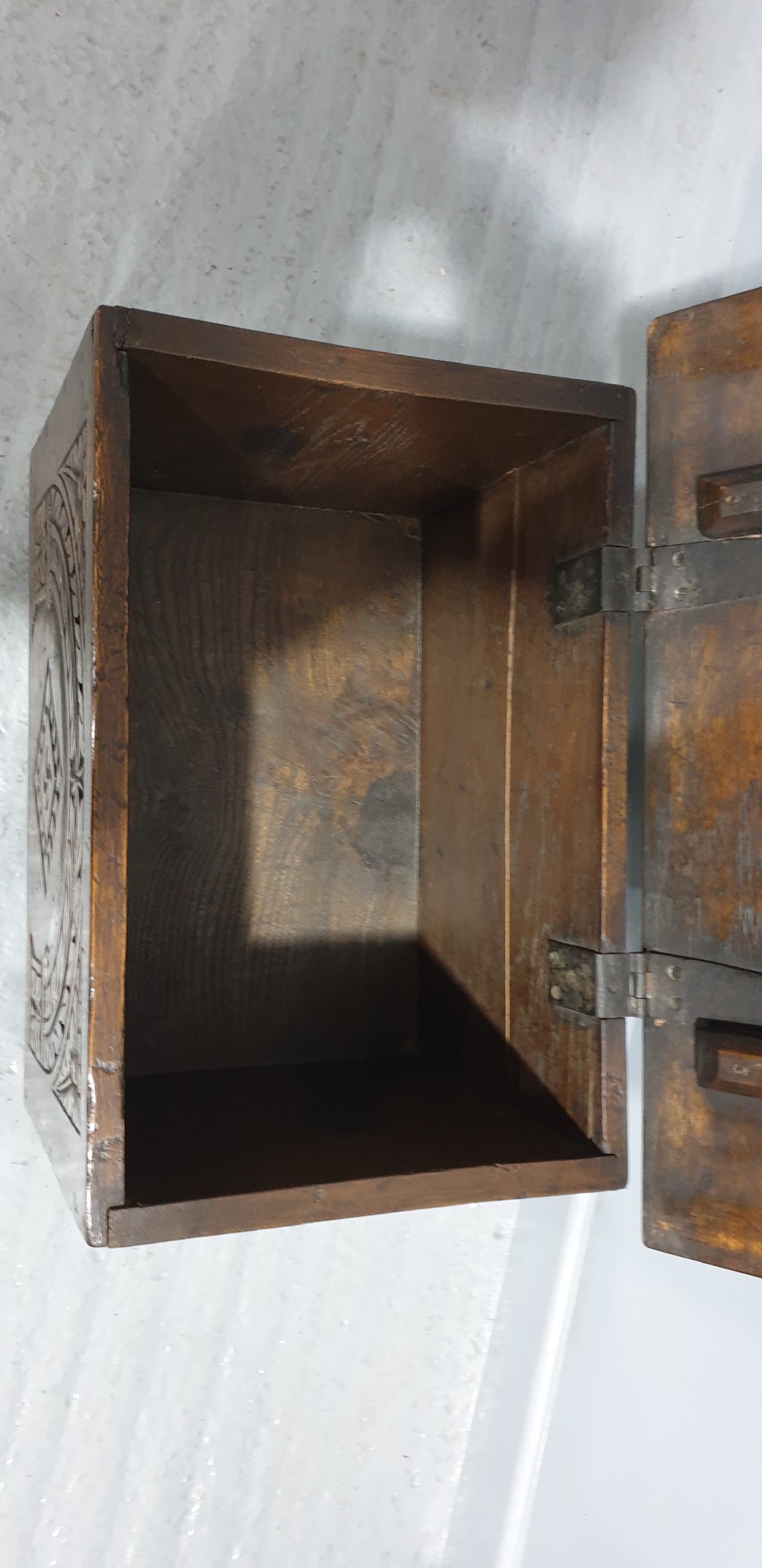 A small dark oak coffer featuring detailed arcaded and lozenge carved motifs on the front panel. View IX