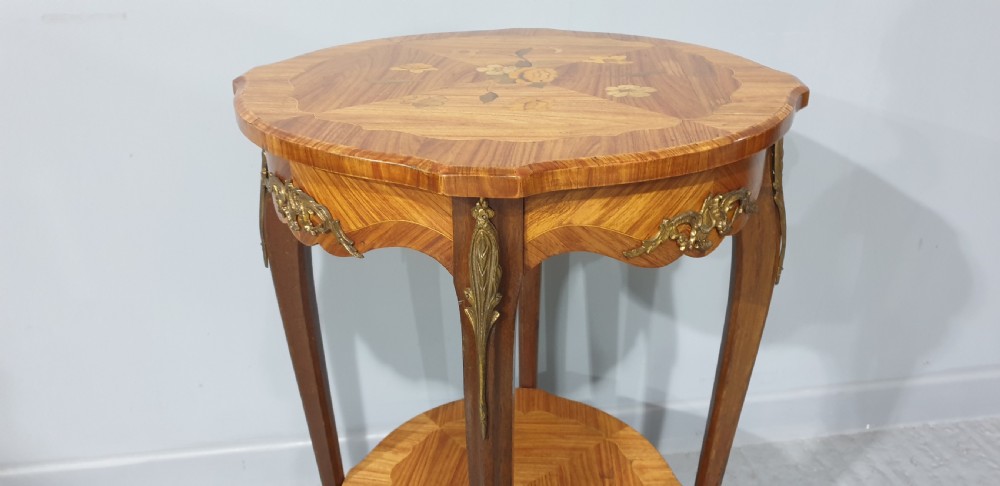 A French Louis XV style occasional table with floral marquetry inlay, slender cabriole legs, a lower tier, and gilt bronze mounts. View III
