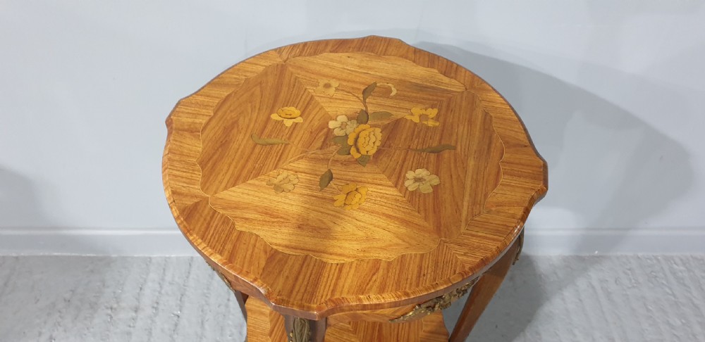 A French Louis XV style occasional table with floral marquetry inlay, slender cabriole legs, a lower tier, and gilt bronze mounts. View IV