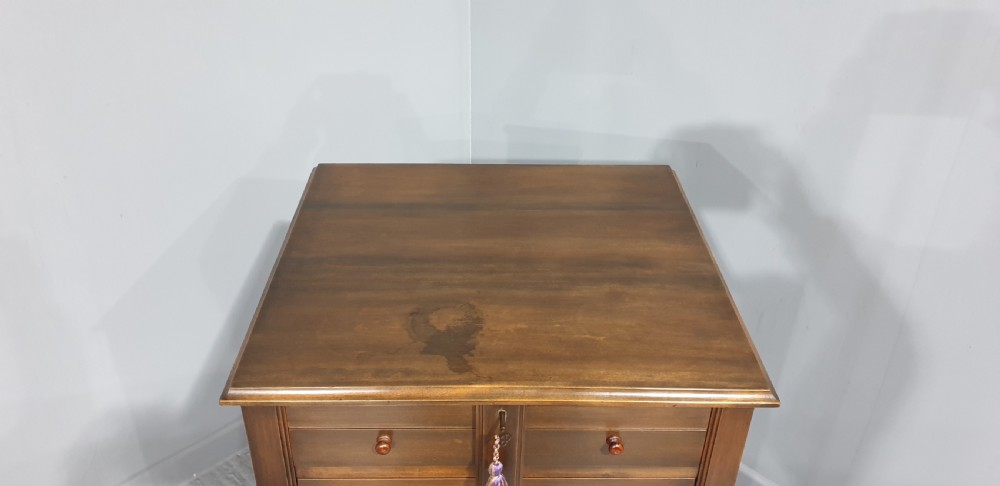 A tall warm brown wooden specimen chest of drawers featuring seven shallow drawers with turned knobs and a central vertical locking bar. View IV