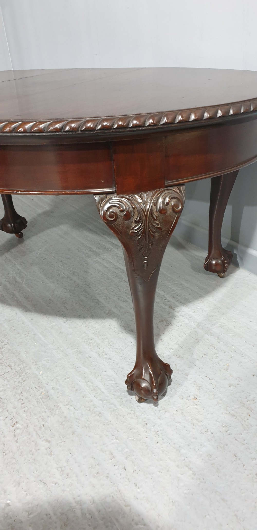 An oval Victorian mahogany extending dining table with carved cabriole legs terminating in ball and claw feet. View II