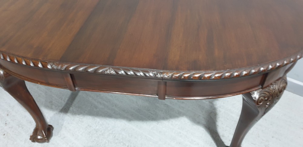 An oval Victorian mahogany extending dining table with carved cabriole legs terminating in ball and claw feet. View III