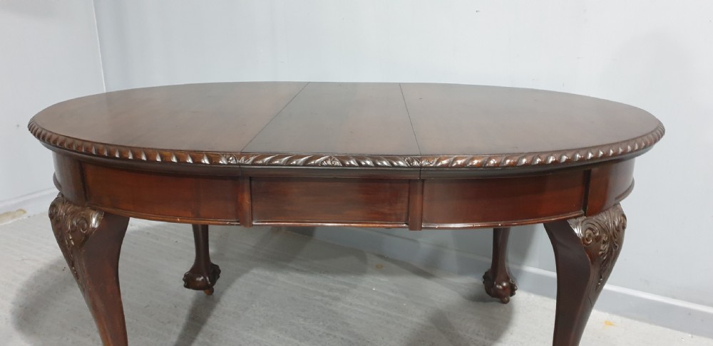 An oval Victorian mahogany extending dining table with carved cabriole legs terminating in ball and claw feet. View V