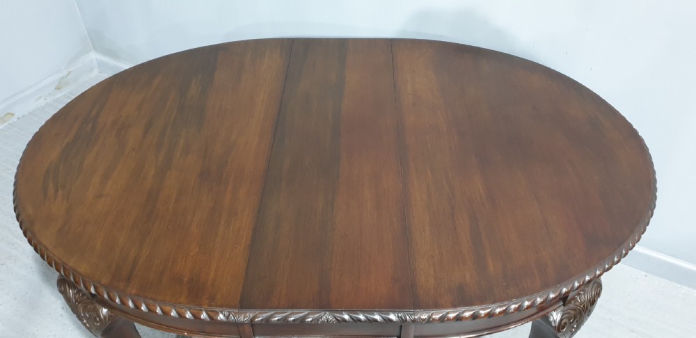An oval Victorian mahogany extending dining table with carved cabriole legs terminating in ball and claw feet. View VI