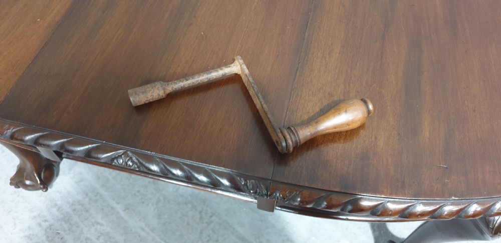 An oval Victorian mahogany extending dining table with carved cabriole legs terminating in ball and claw feet. View VIII