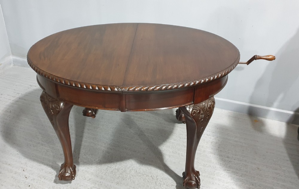 An oval Victorian mahogany extending dining table with carved cabriole legs terminating in ball and claw feet. View X