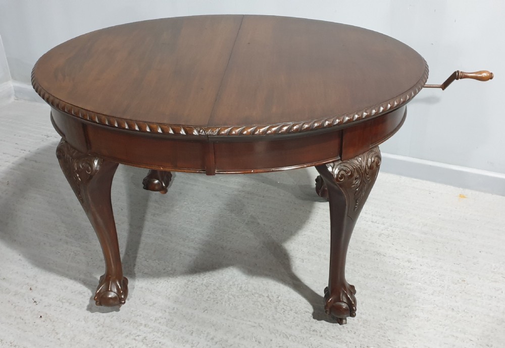 An oval Victorian mahogany extending dining table with carved cabriole legs terminating in ball and claw feet. View XI