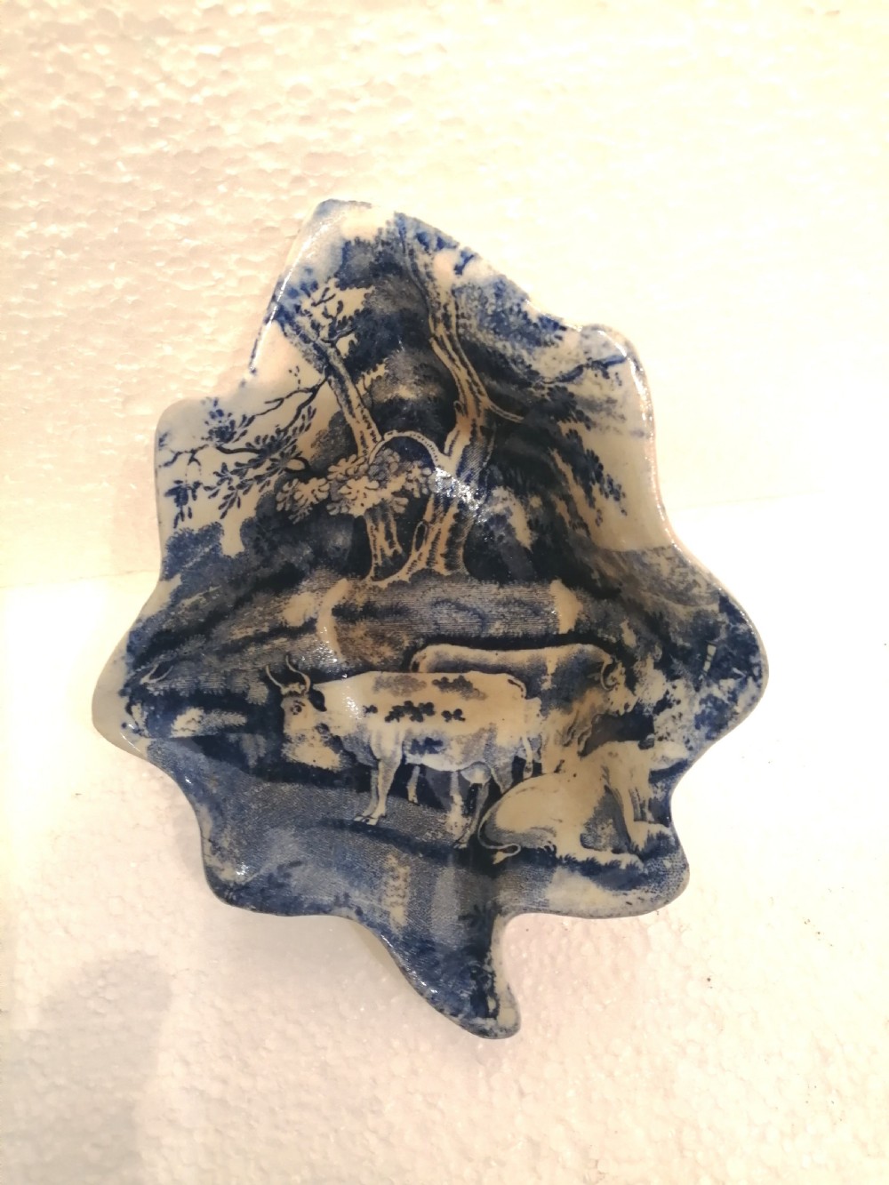 A leaf-shaped Georgian porcelain dish featuring a cobalt blue underglaze transfer print depicting cattle beneath trees. View II