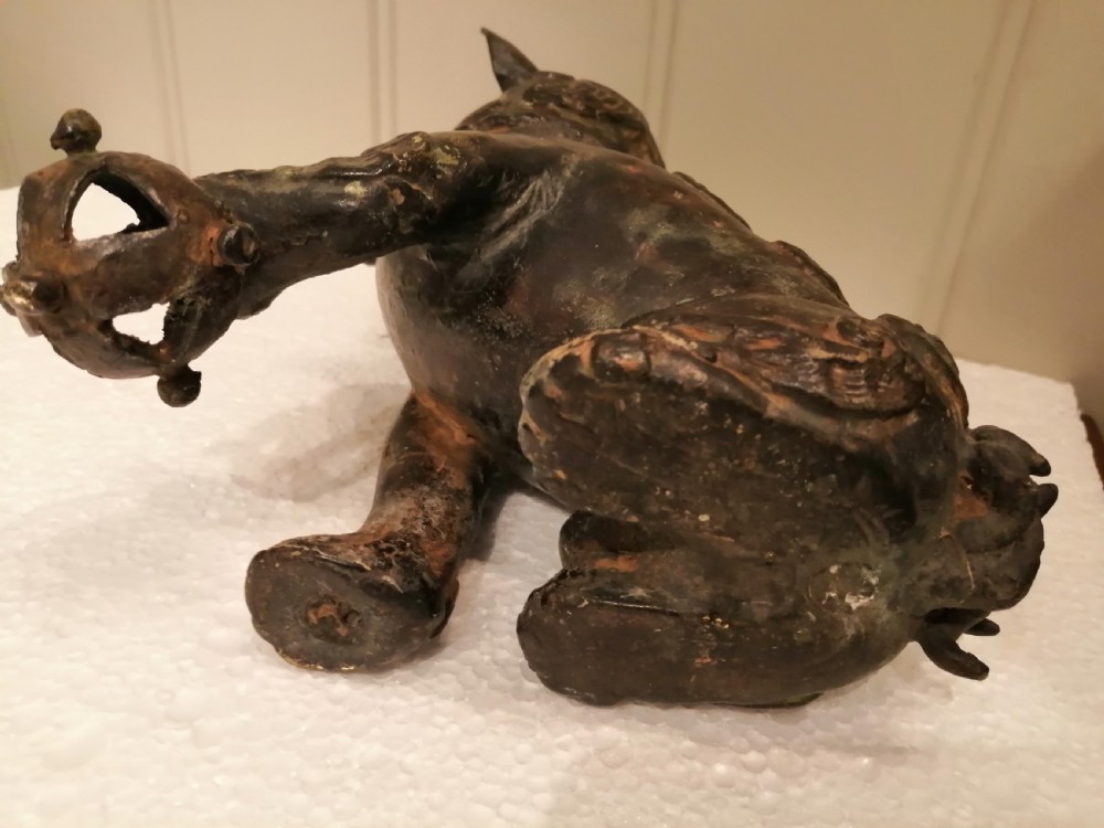 An 18th-century dark patinated hollow bronze Japanese foo dog sculpture seated on its hind legs with one paw resting on a sphere. View XII