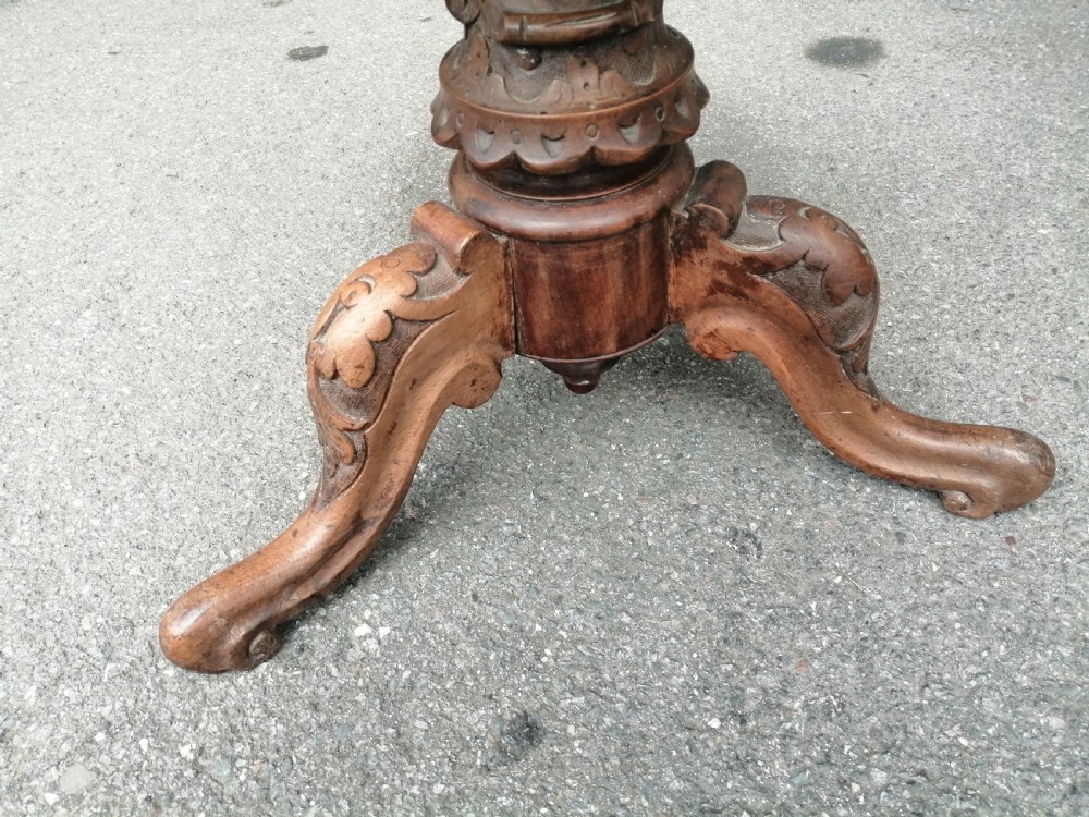 A 19th-century Victorian walnut rise and fall piano stool featuring a circular light blue patterned upholstered seat with fringed trim set on a carved tripod base. View II